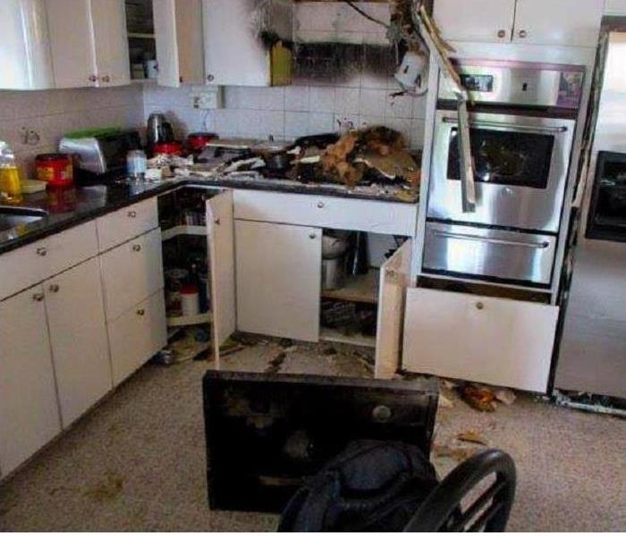 burned back wall, no microwave, range top on floor, charred debris on kitchen counters