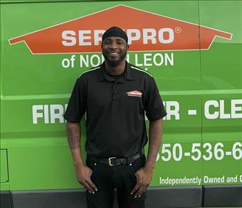 SERVPRO® crew member standing in front of a SERVPRO vehicle 