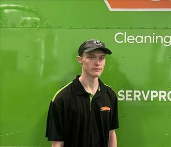 SERVPRO® crew member standing in front of a SERVPRO vehicle