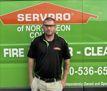 male employee standing in front of a vehicle