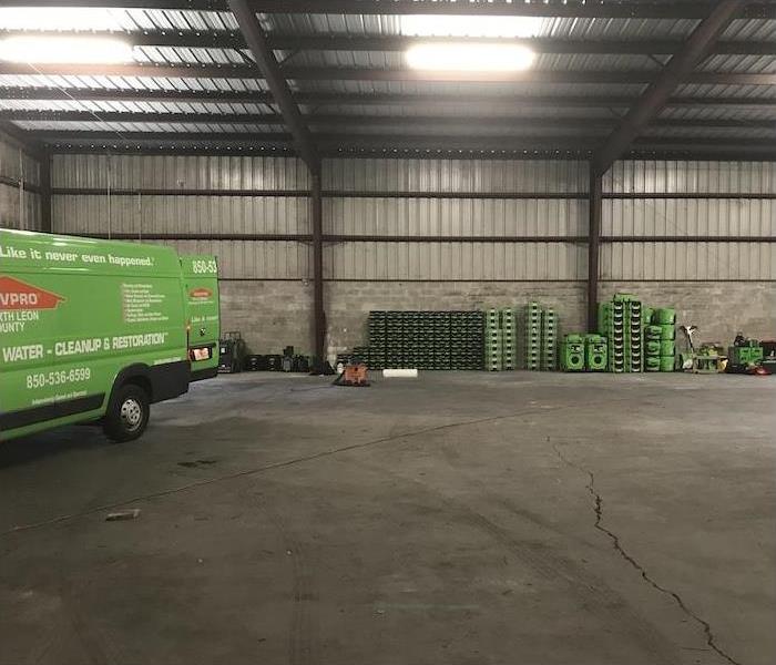 Warehouse with a SERVPRO van and various pieces of equipment stacked against the wall