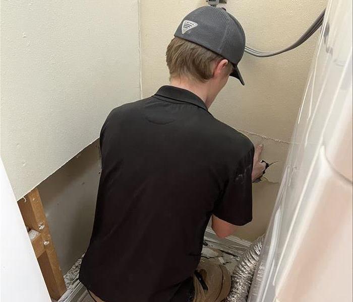 SERVPRO technician repairing water damaged wall